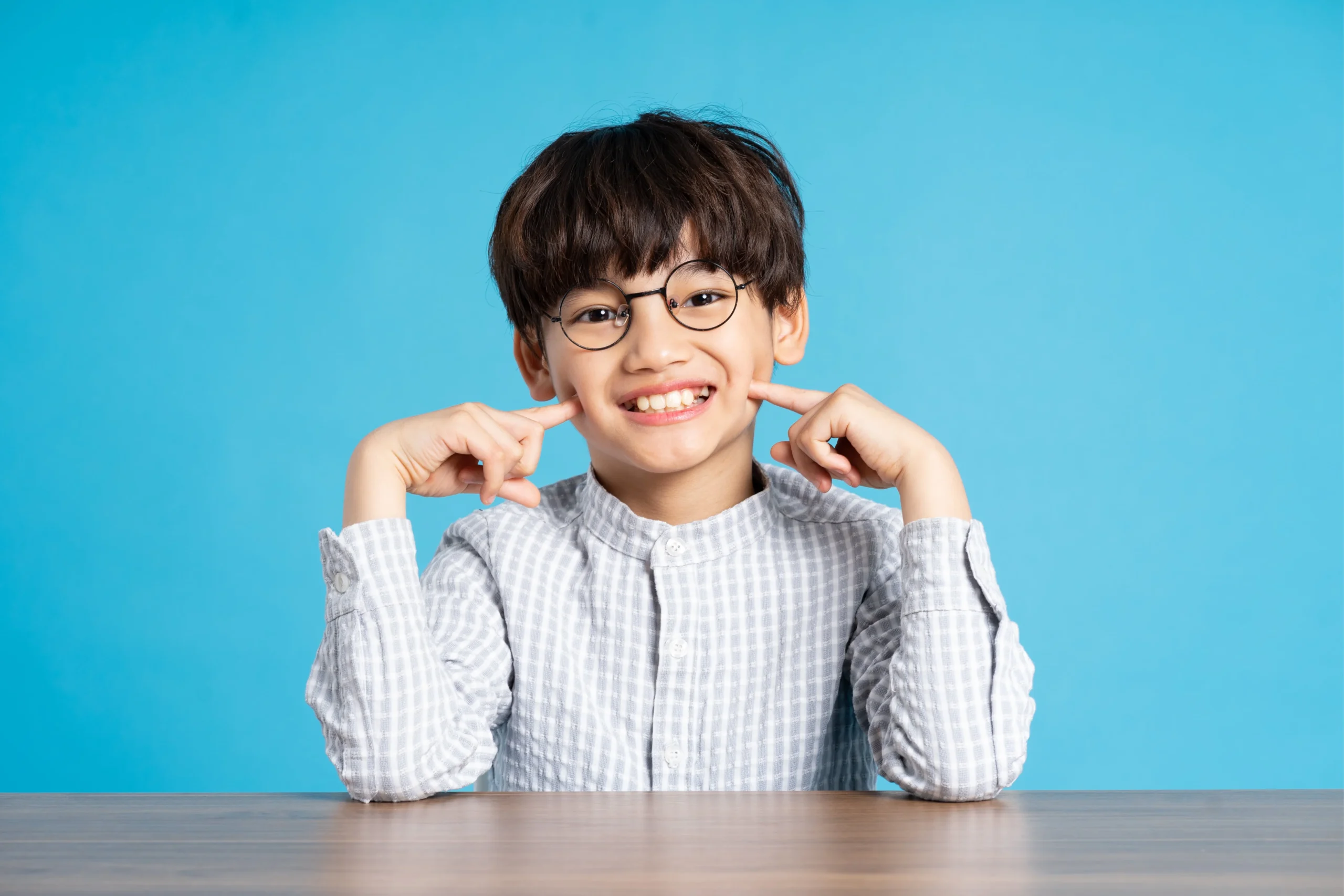 Orthodontic Headgear, Jumeirah Dubai 7 portrait school boy sitting studying blue background min